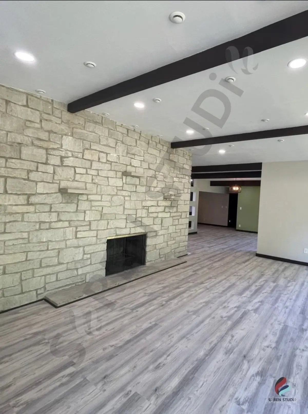 Living room with stone fireplace and beams